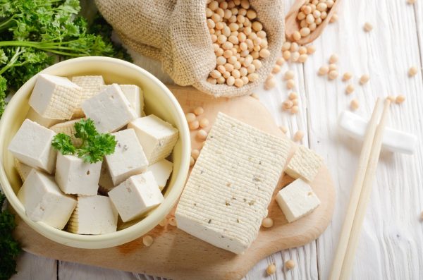 Tofu in a White Ceramic Bowl Next to Soybeans in a Hemp Sack